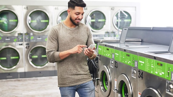 Customer using phone at laundry shop